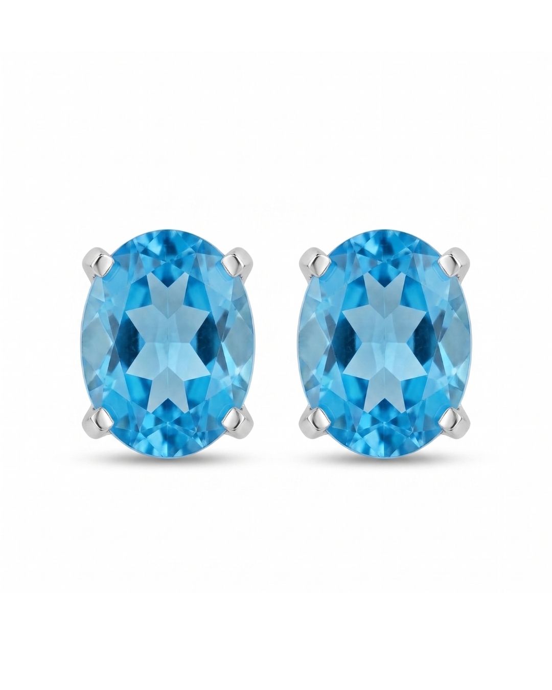 Aretes tipo topitos Riviera de Pedra con gema azul en corte ovalado y montura de cuatro garras sobre fondo blanco
